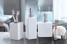 Weiße Badaccessoires mit Seifenspendern, Zahnbürsten und Lippenstift