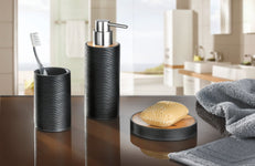 Schwarzes Badset mit Seifenspender, Becher, Schale und Handtuch auf Waschtisch