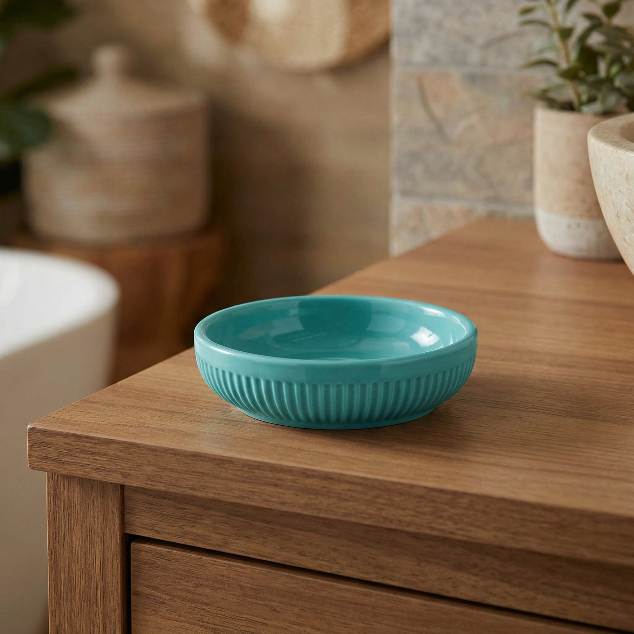 Türkise Seifenschale aus Keramik auf hölzerner Badezimmerkommode
