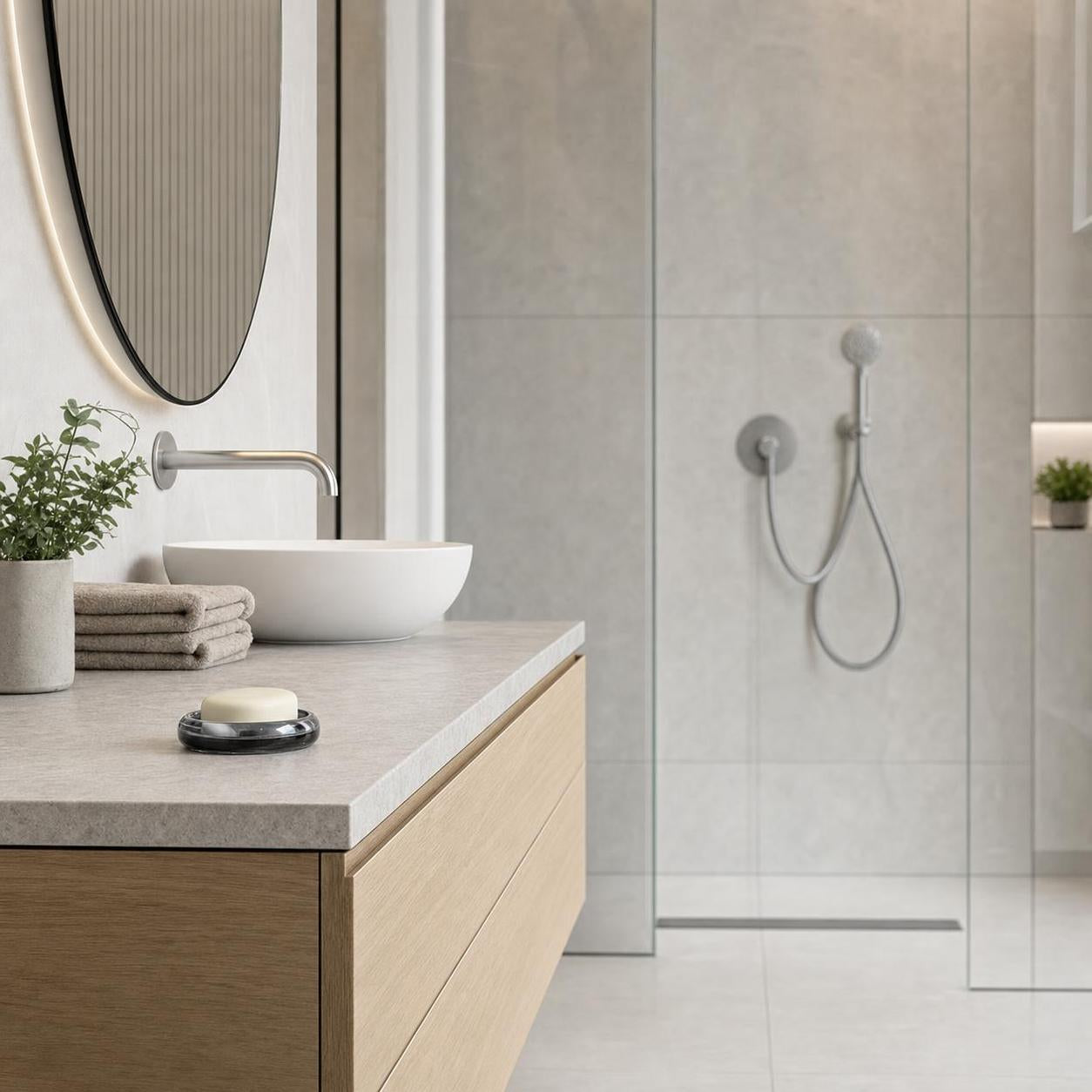 Ein modernes Bad zeigt Aufsatzwaschbecken, Holzwaschtisch und Glasdusche.