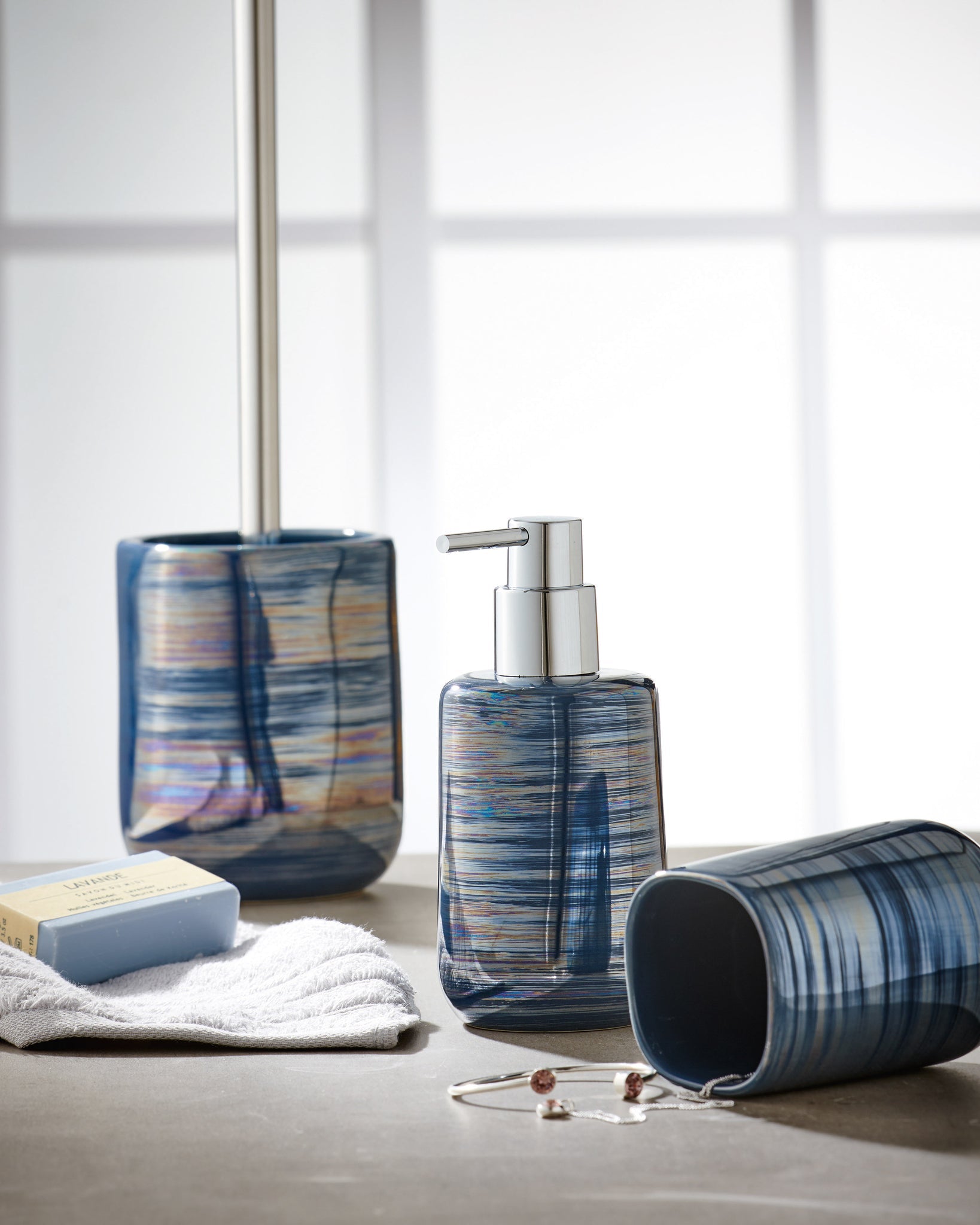 Seifenspender ARGENTIC Mare steht mit passendem Bad-Set, Seife und Schmuck auf heller Oberfläche.