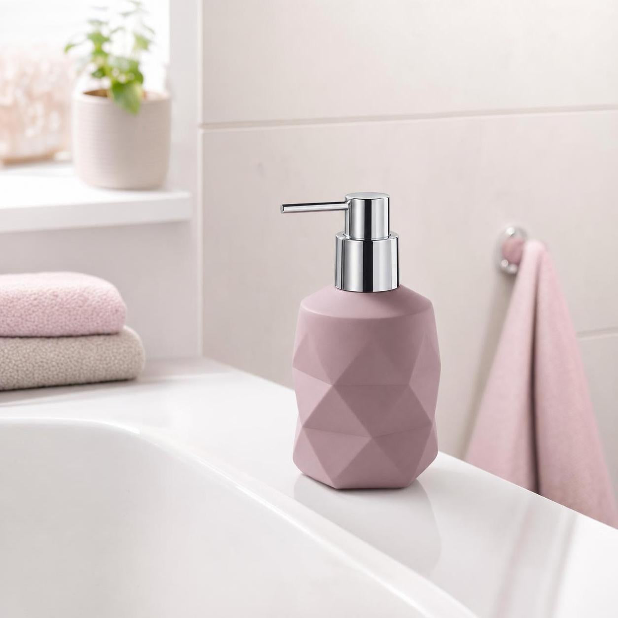 Ein rosa facettierter Seifenspender mit Chrompumpe steht auf dem Waschbecken.