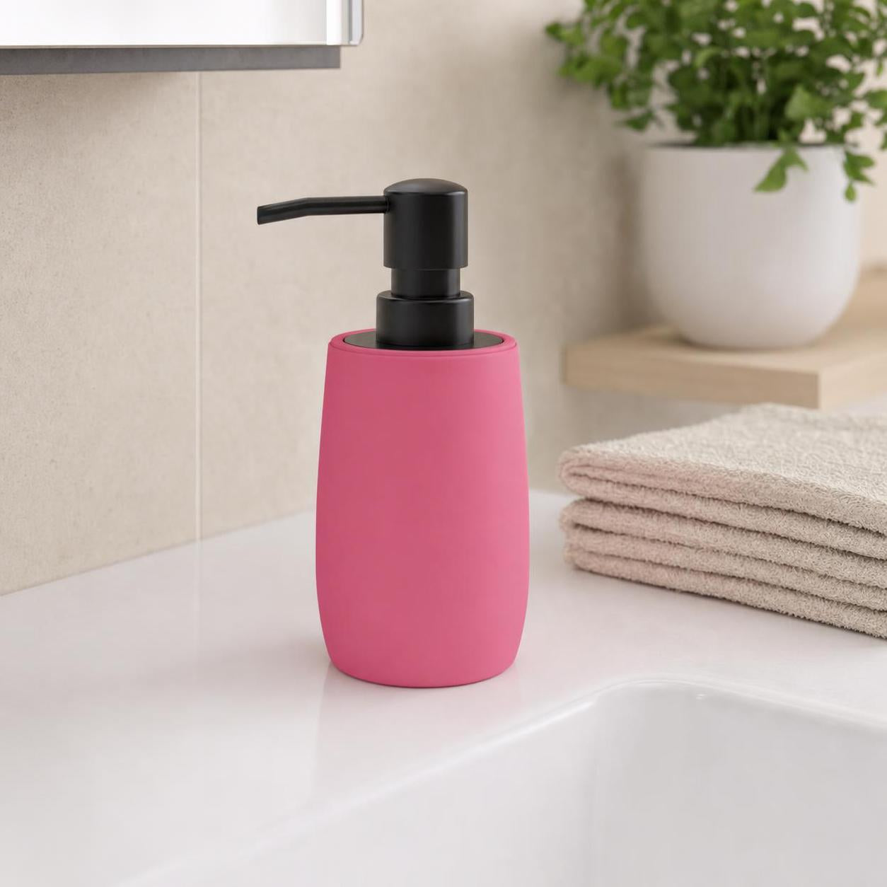 Ein rosa Seifenspender mit schwarzer Pumpe steht am Waschbecken.
