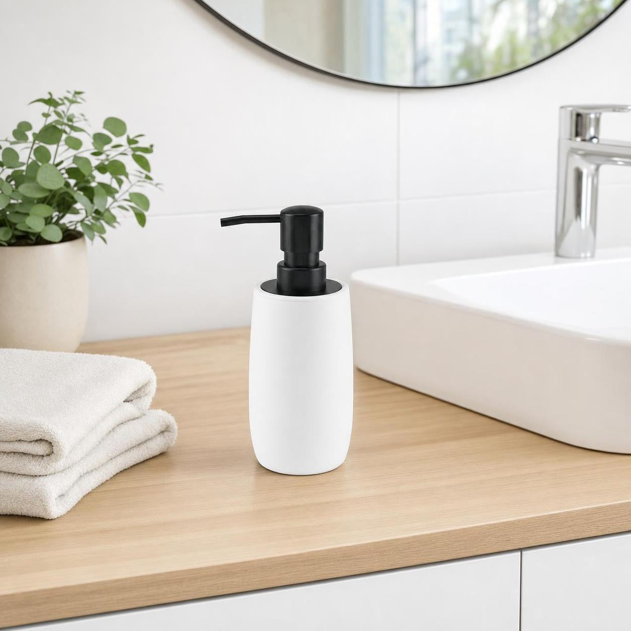 Ein weißer Seifenspender mit schwarzer Pumpe steht am Waschbecken.