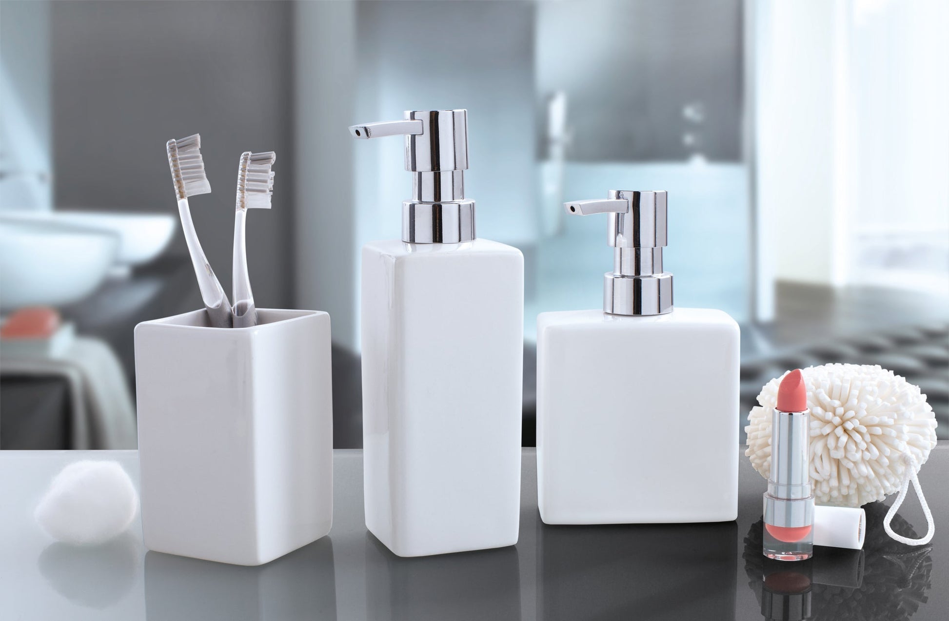 Weiße Badaccessoires mit Seifenspendern, Zahnbürsten und Lippenstift auf Ablage