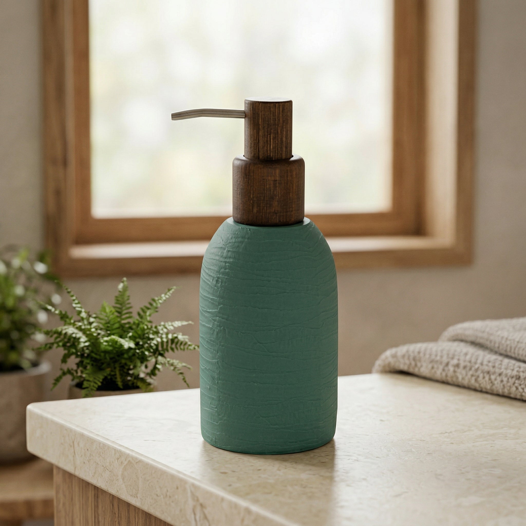Grüner Seifenspender aus Keramik mit Holzpumpe auf heller Badablage