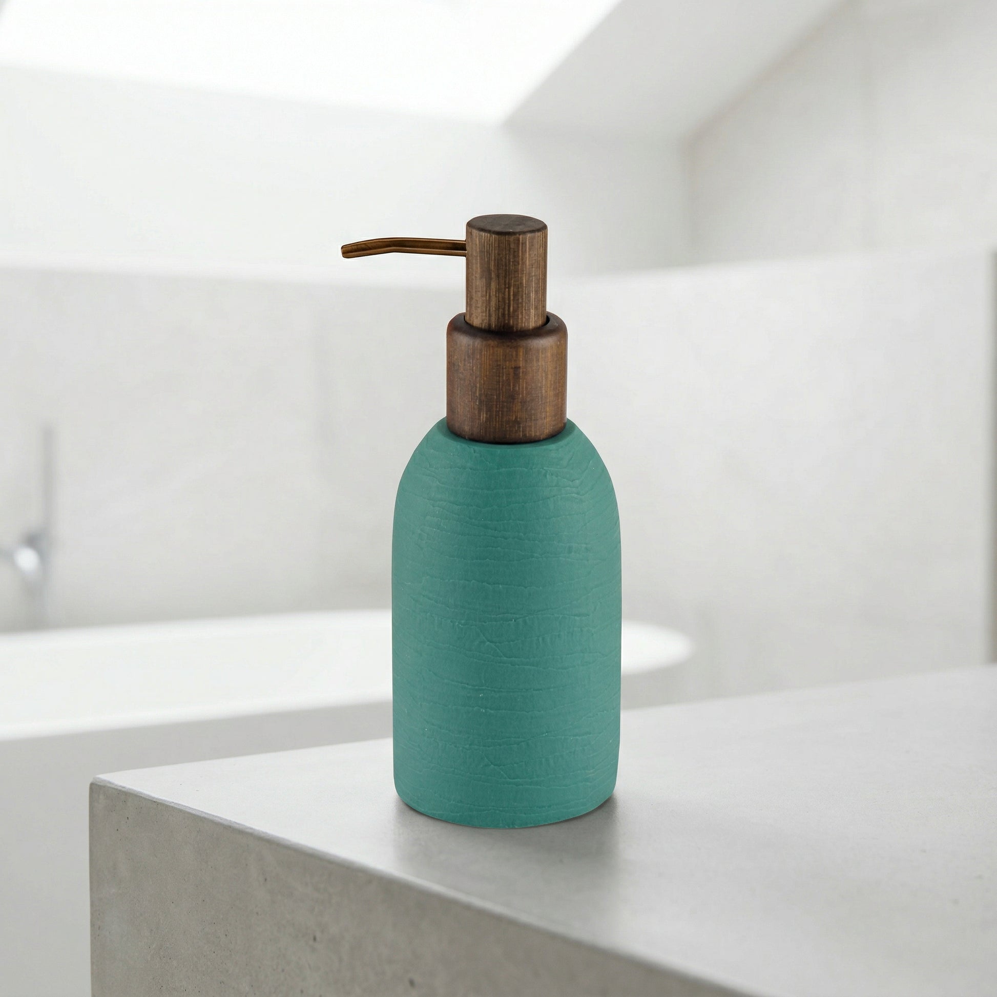 Türkiser Seifenspender mit Holzpumpe auf grauer, moderner Badablage im Bad