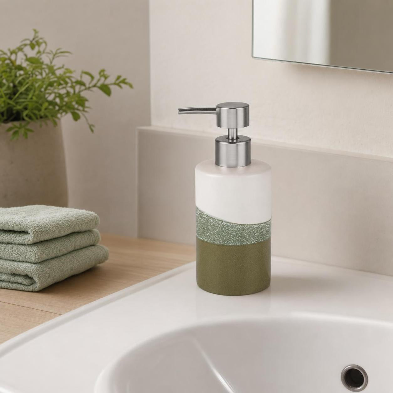 Ein grüner Seifenspender steht am Waschbecken neben Handtüchern.