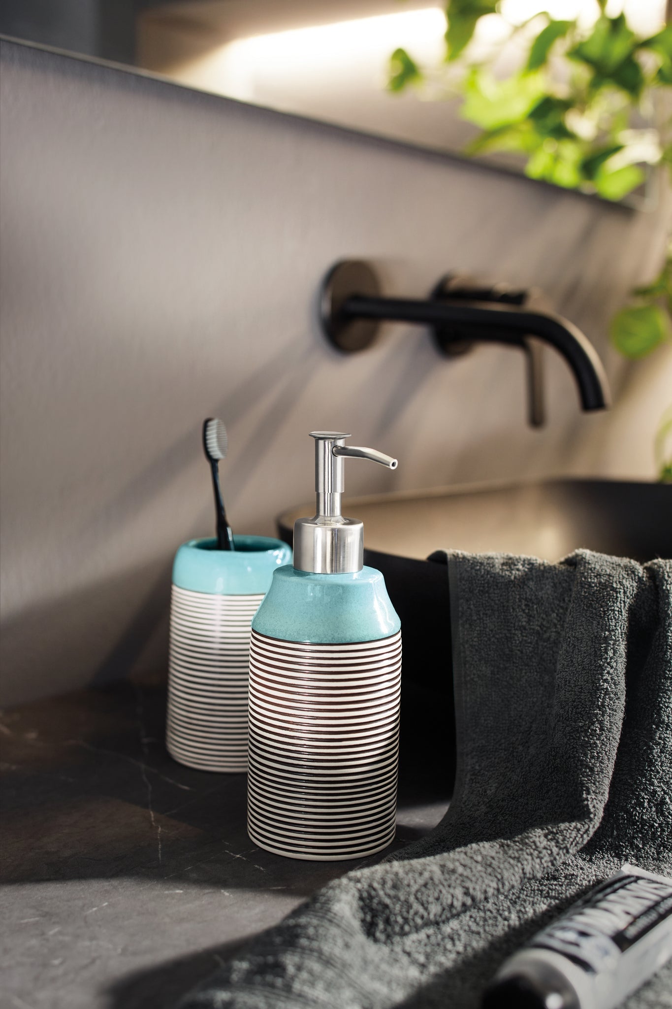 Seifenspender OKAPI Mauritius steht im modernen Bad neben Zahnputzbecher und Waschbecken.