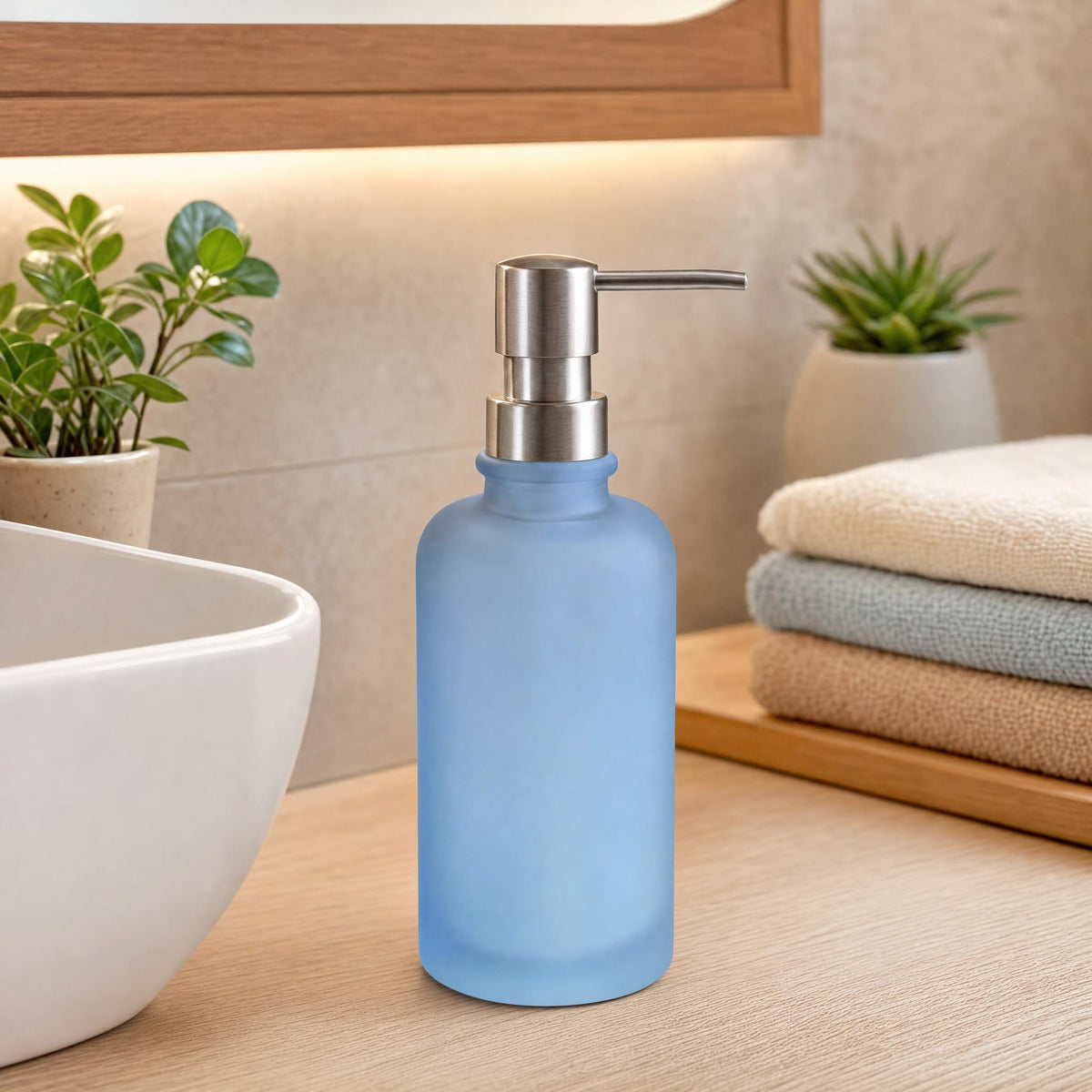 Blauer Seifenspender aus Glas auf Holzwaschtisch neben Waschbecken.