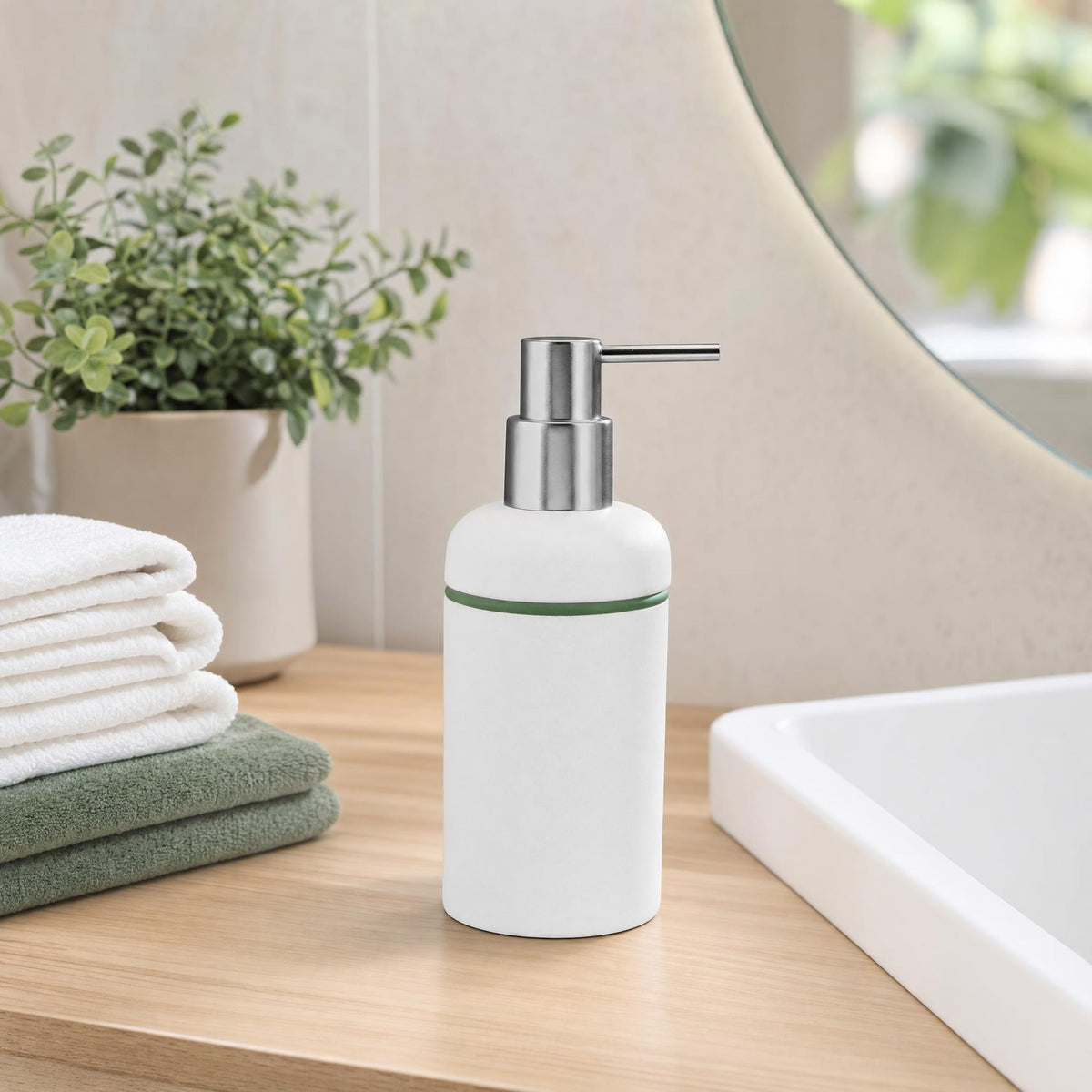 Weißer Seifenspender auf Holzablage neben Waschbecken, Handtüchern und Pflanze.
