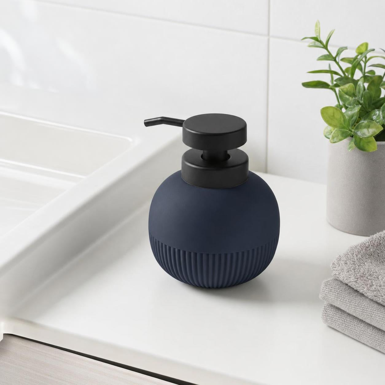 Blauer Seifenspender mit schwarzer Pumpe steht am Waschbecken.