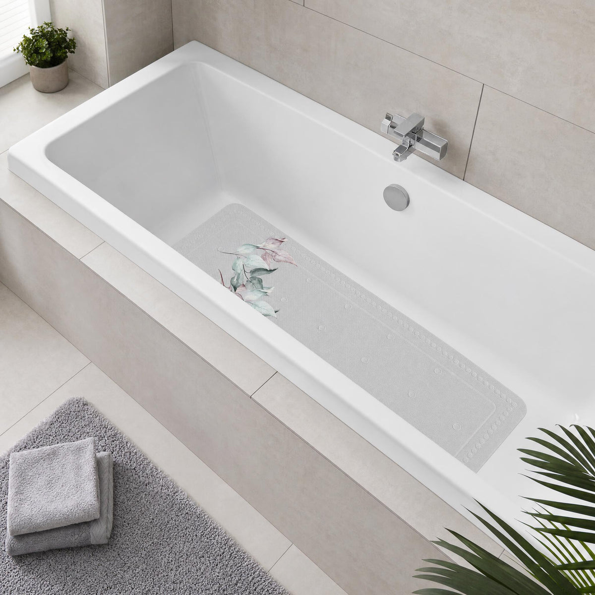 Weiße Badewanne mit floralem Wanneneinleger in modernem Badezimmer.