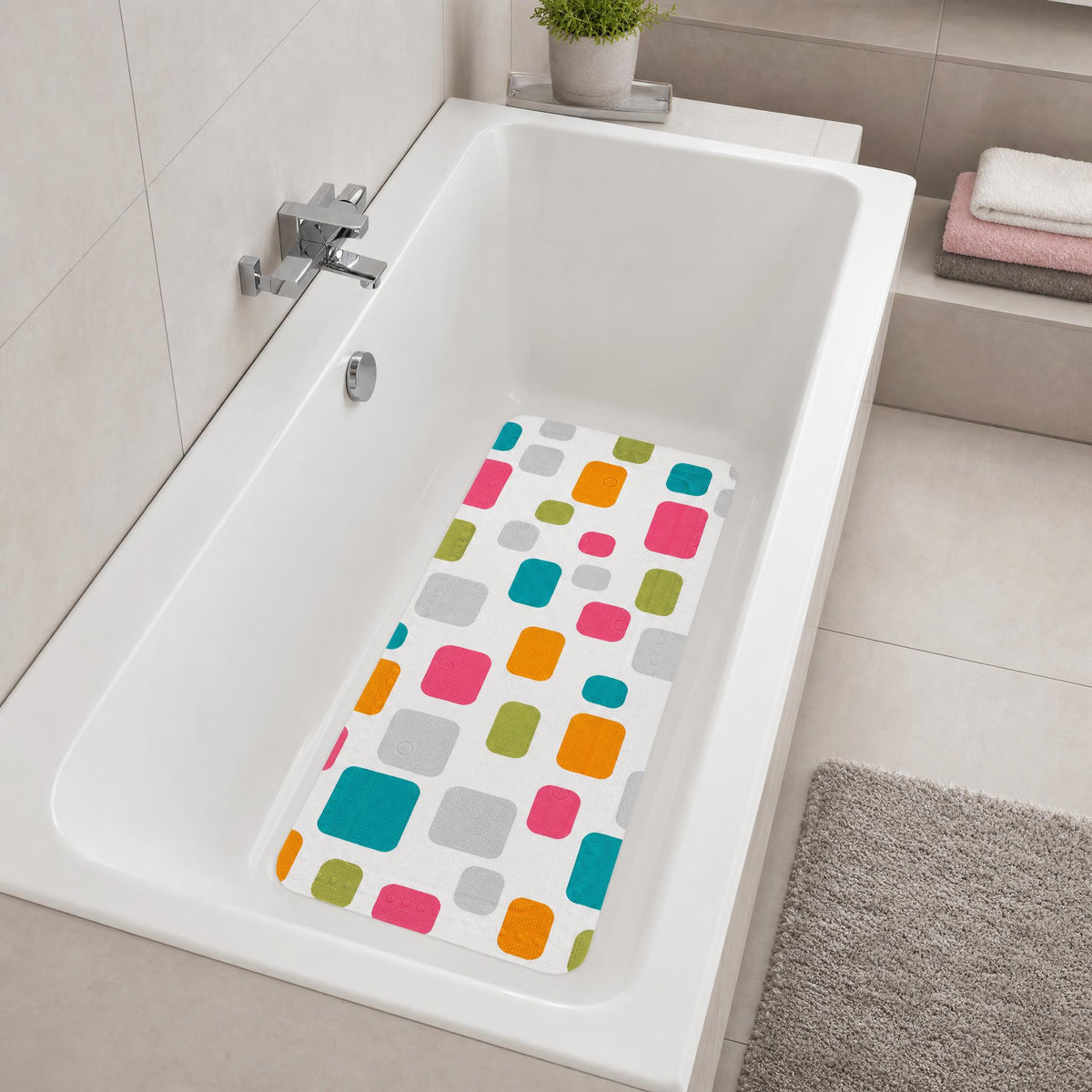 Weiße Badewanne mit bunter Antirutschmatte im modernen Badezimmer.