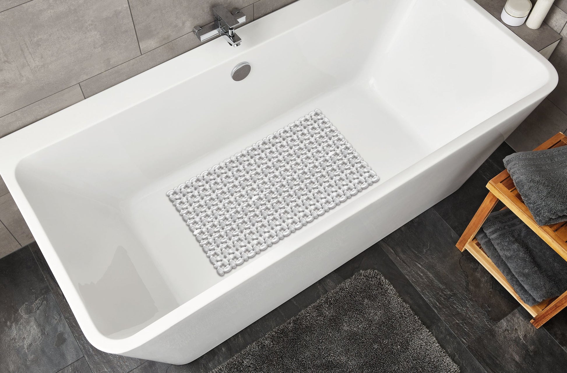 Wanneneinlage IVY Clear 39 x 69 cm liegt rutschhemmend in einer weißen Badewanne im modernen Badezimmer.