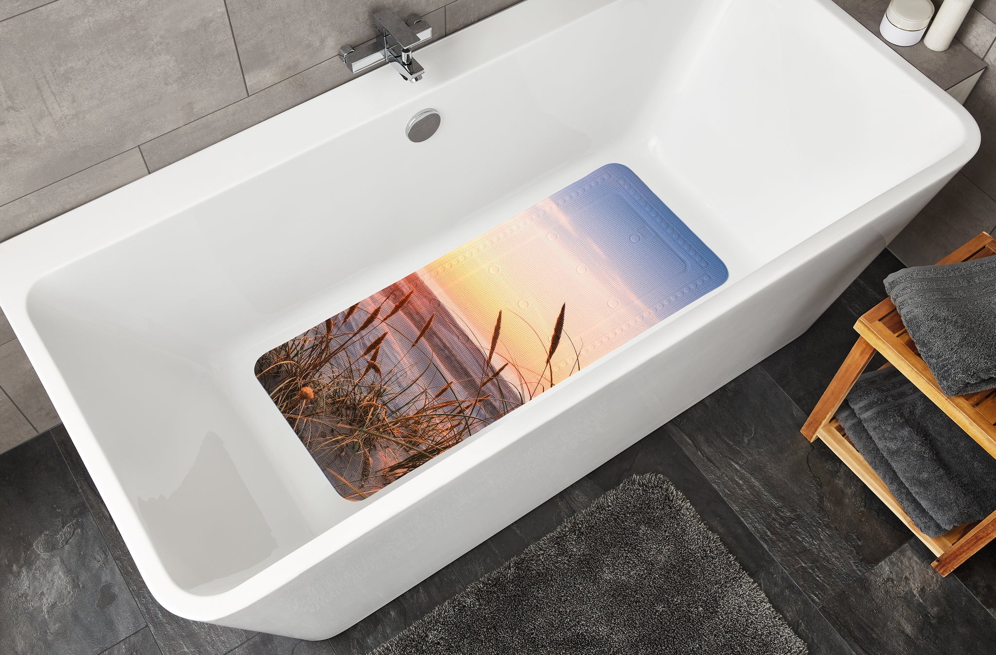 Badewanneneinlage mit Strandmotiv in weißer Wanne mit Armatur oben