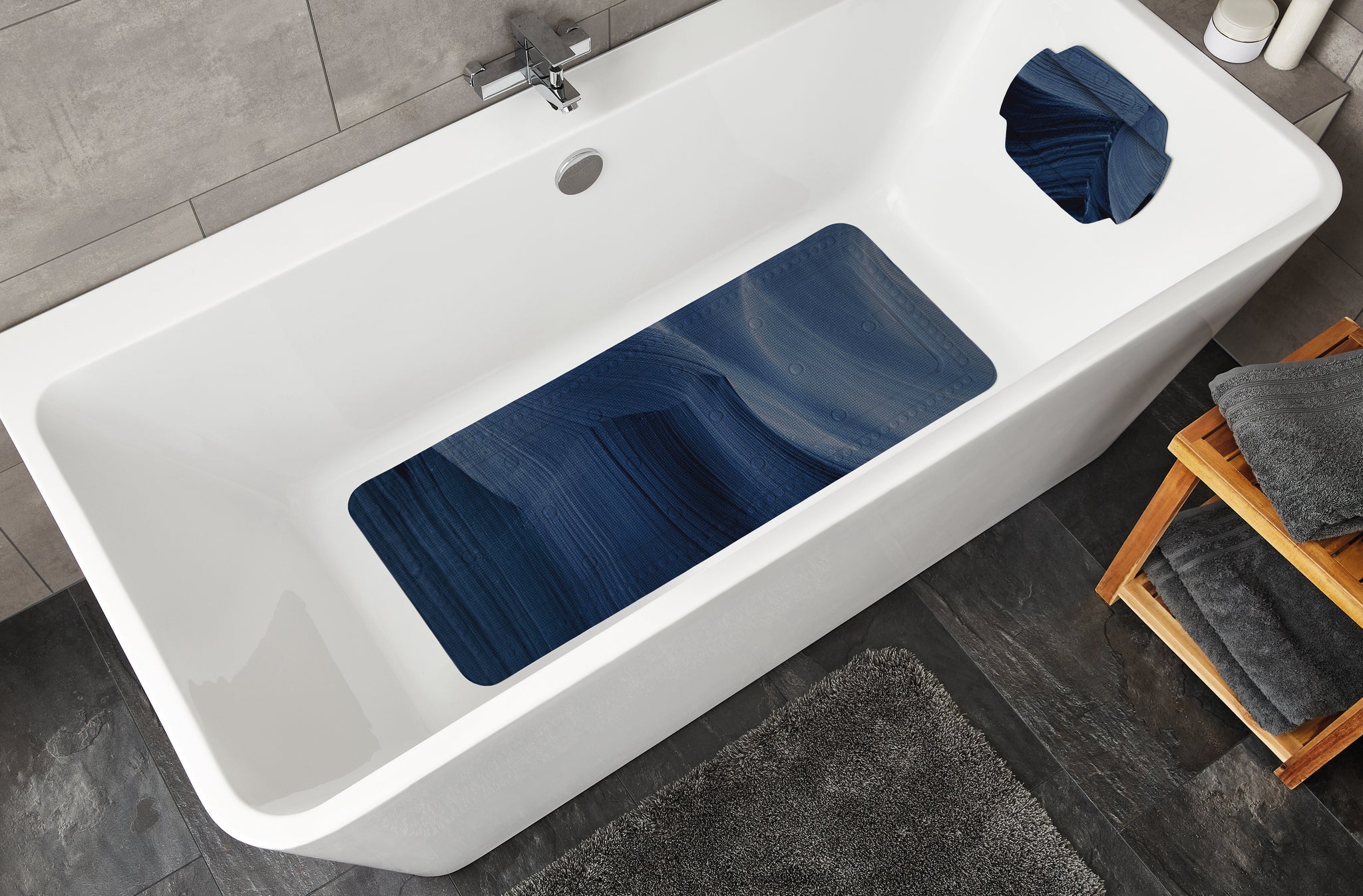 Weiße Badewanne mit Wanneneinlage MYSTIC Navy 36 x 92 cm und passender Kopfauflage im Bad.