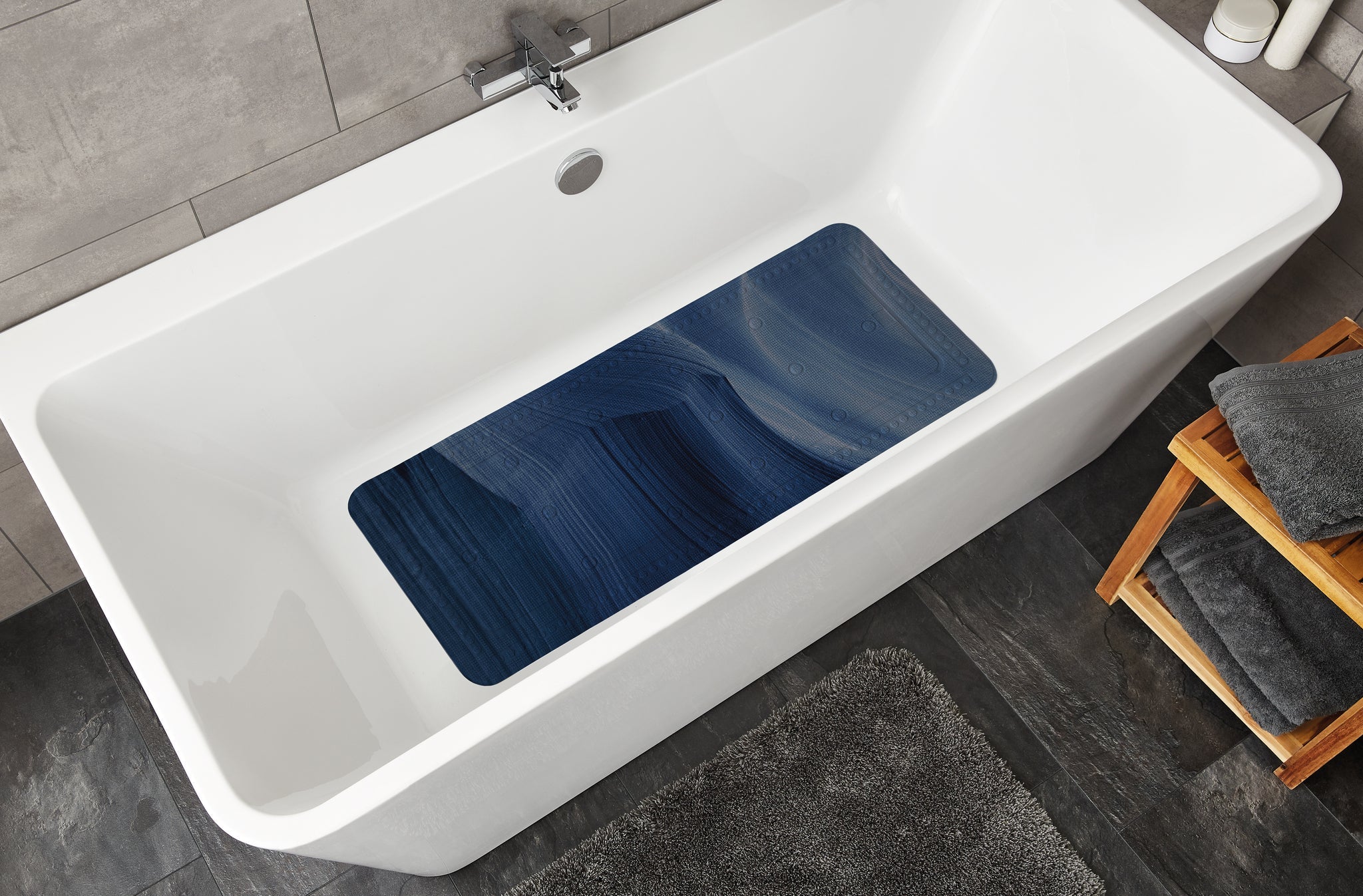 Wanneneinlage MYSTIC Navy 36 x 92 cm liegt in weißer Badewanne in modernem Badezimmer.