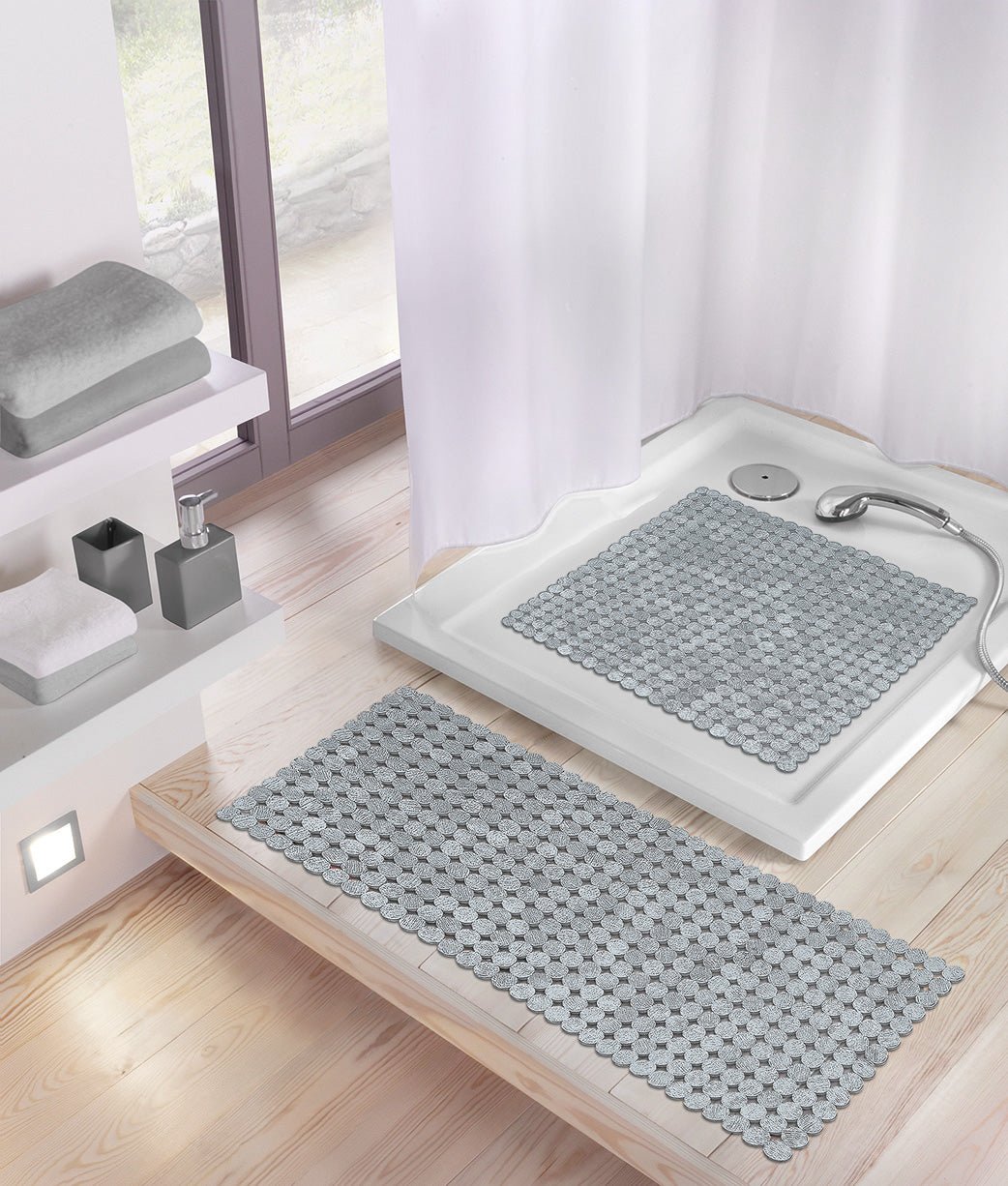 Silberne Wanneneinlage SIGN 36 x 80 cm liegt auf hellem Holzboden vor weißer Dusche.