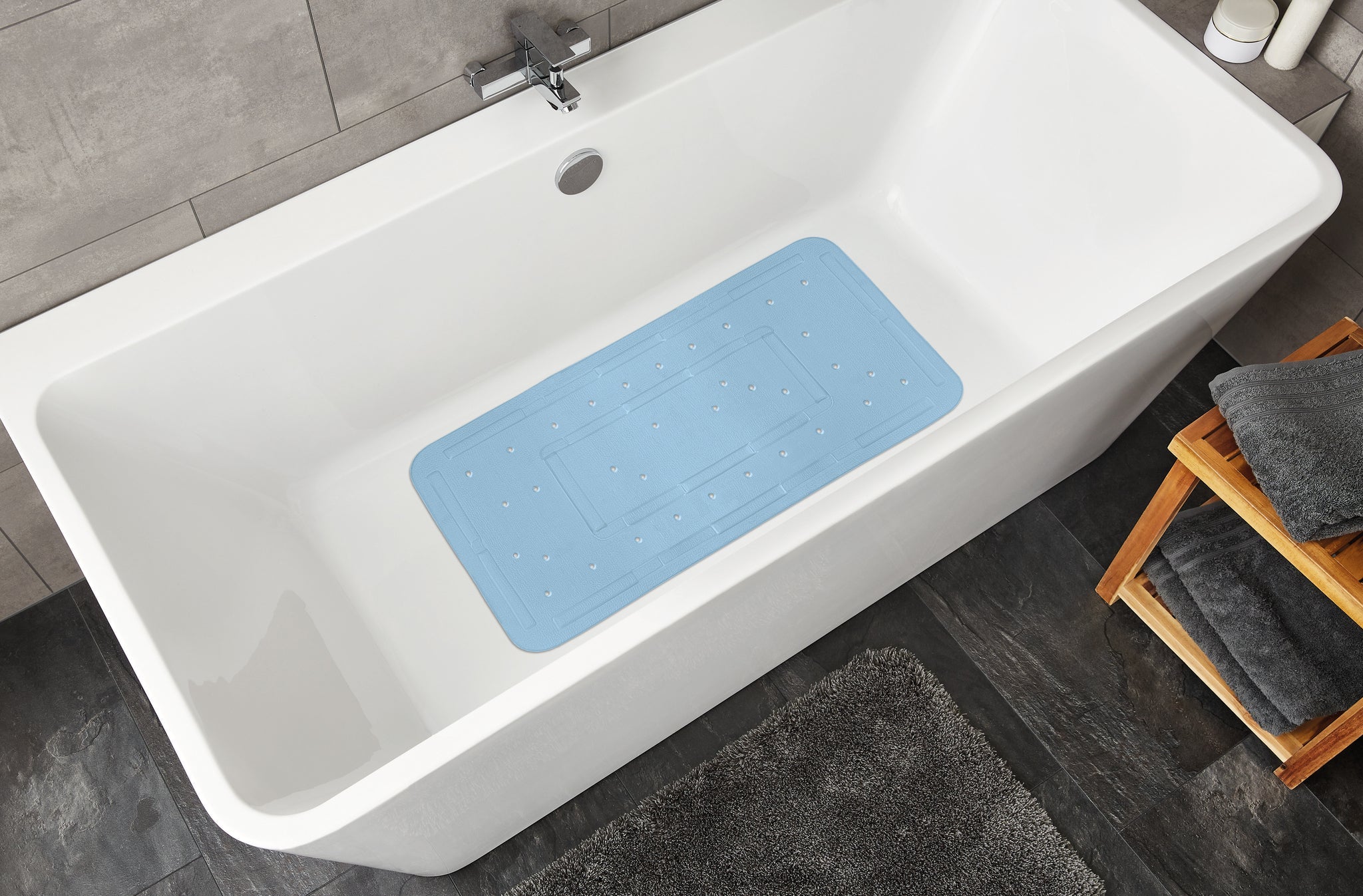 Wanneneinlage SOFTY Azur 36 x 80 cm in weißer Badewanne mit grauem Fliesenboden von oben gesehen.