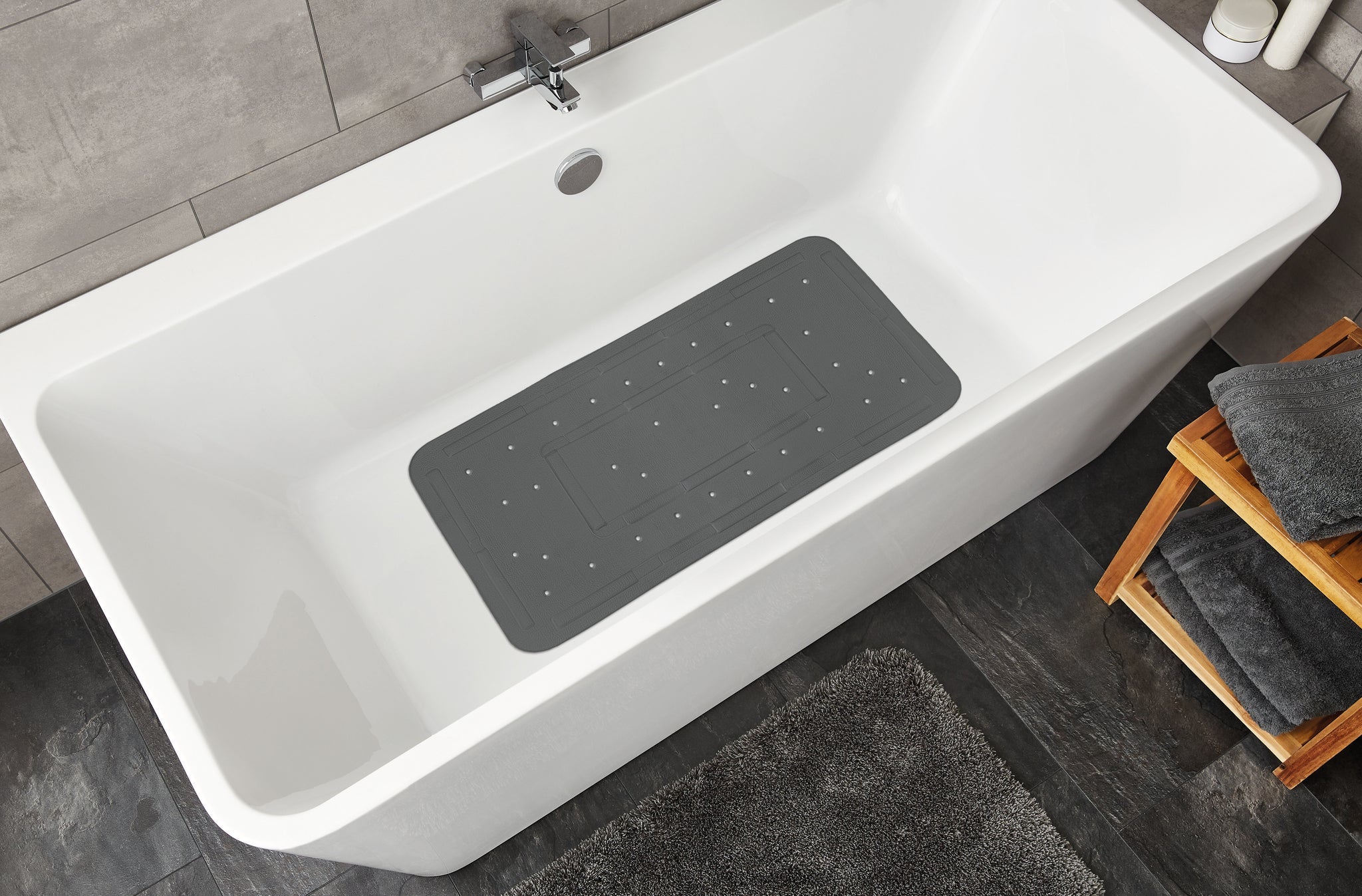 Graue Wanneneinlage SOFTY Schiefer 36 x 80 cm liegt rutschhemmend in einer weißen Badewanne.