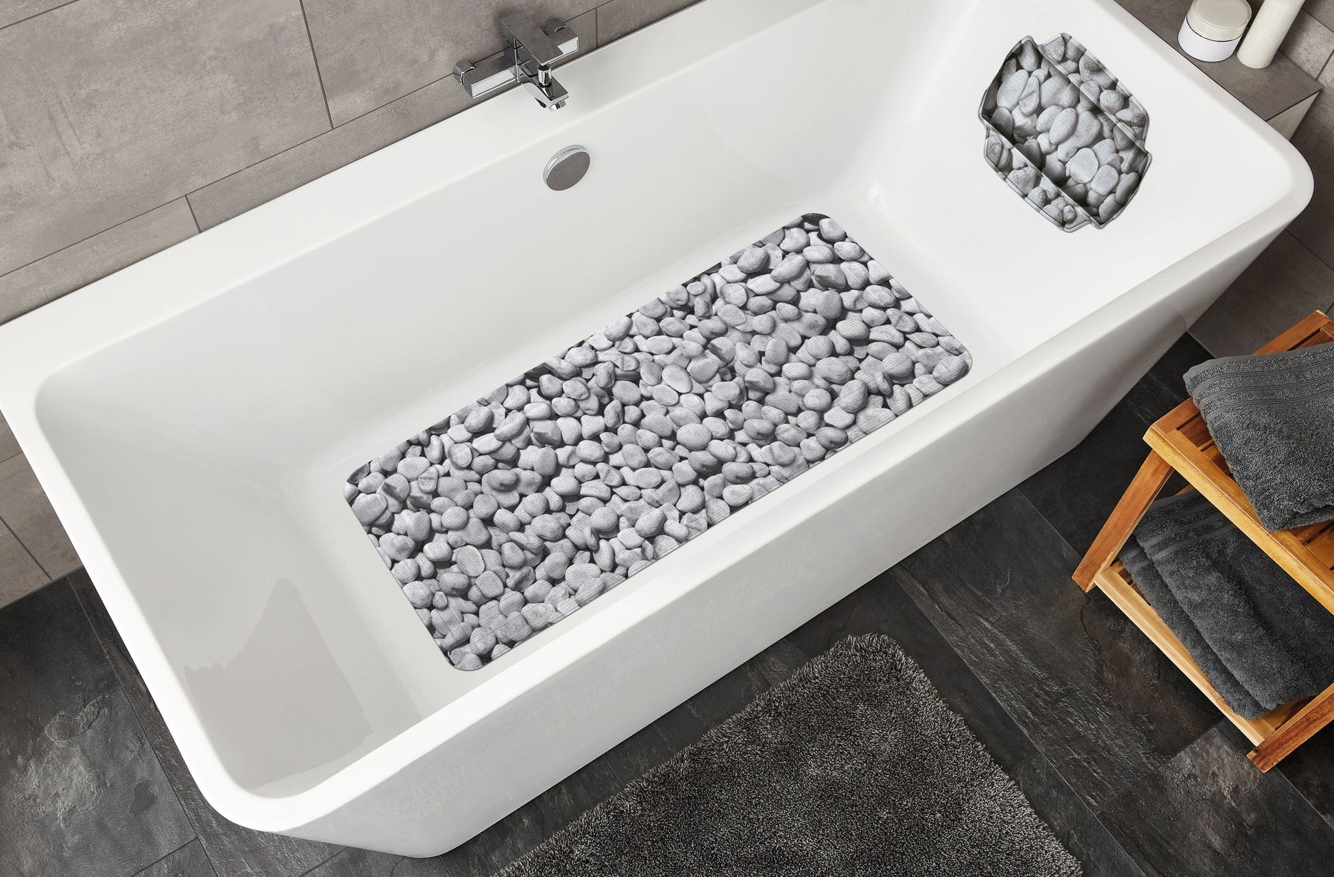 Grau gemusterte Wanneneinlage STEPSTONE 36 x 92 cm liegt in weißer Badewanne mit Steinoptik.