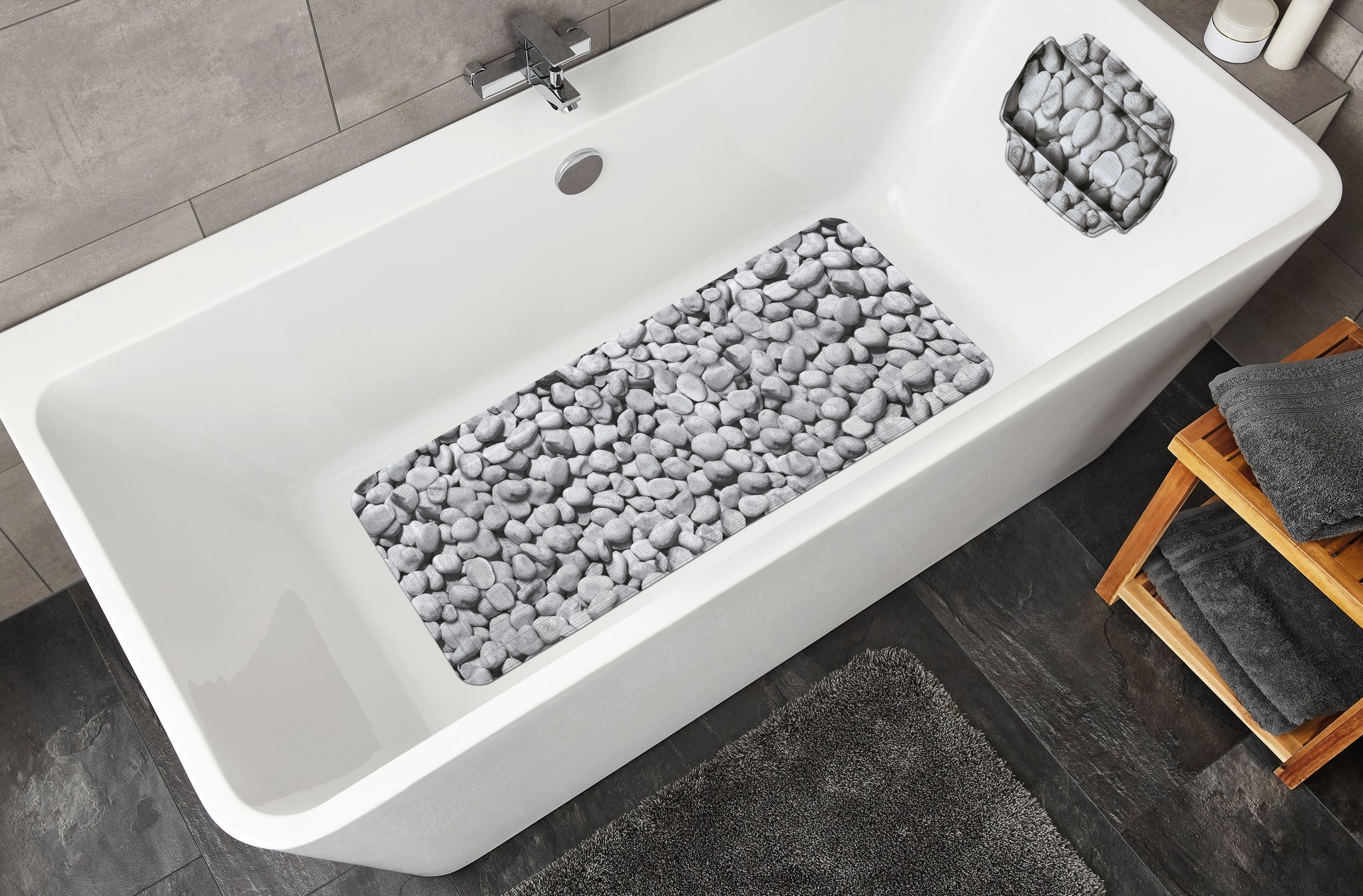 Grau gemusterte Wanneneinlage STEPSTONE 36 x 92 cm liegt in weißer Badewanne mit Steinoptik.