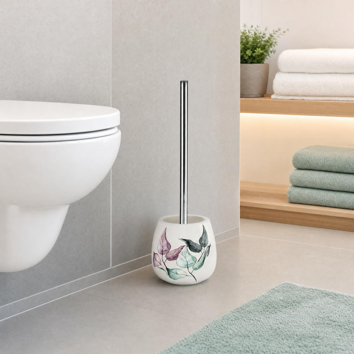 WC-Bürste mit Blättermotiv neben Toilette im modernen Badezimmer.
