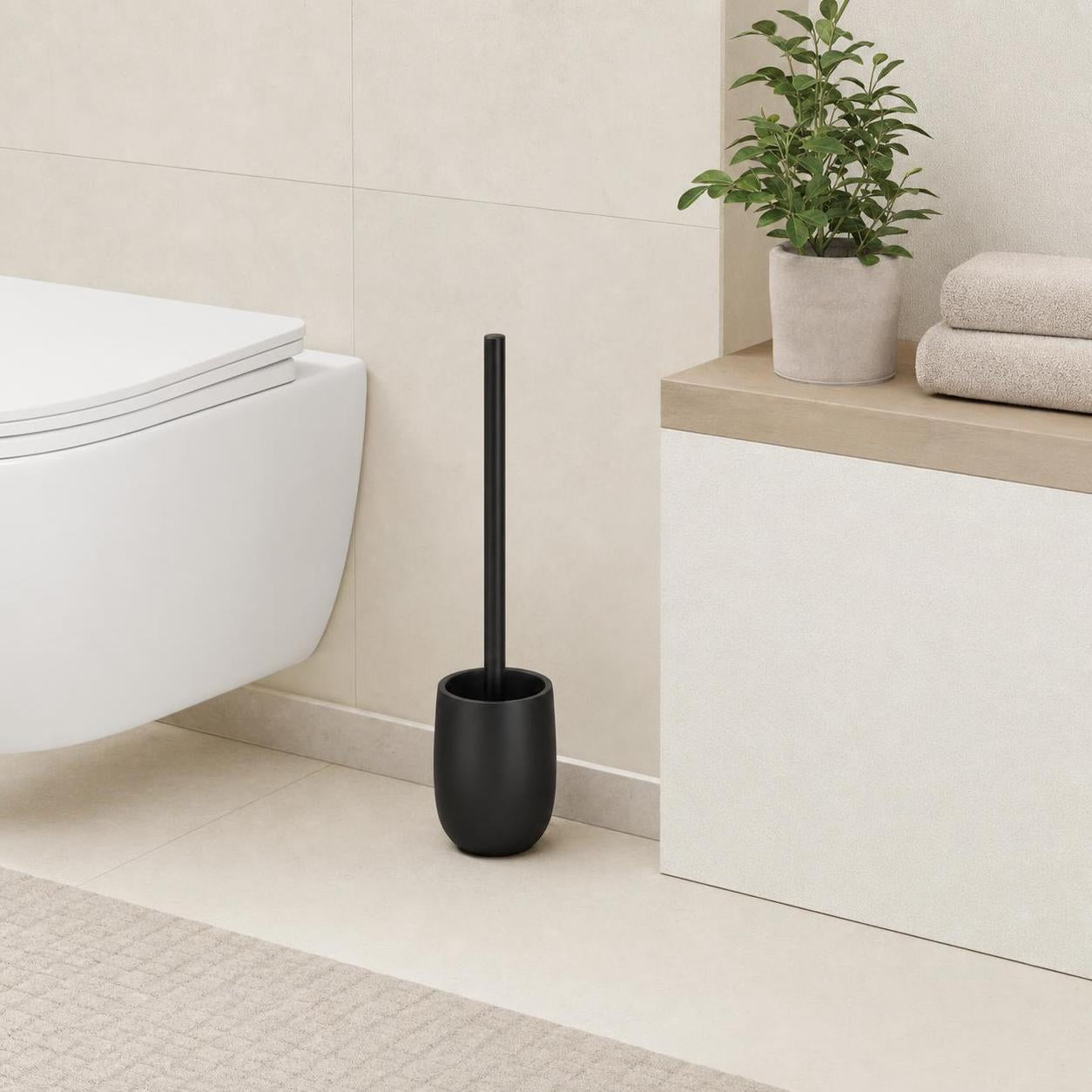 Schwarze WC-Bürste steht neben der Toilette im modernen Bad.