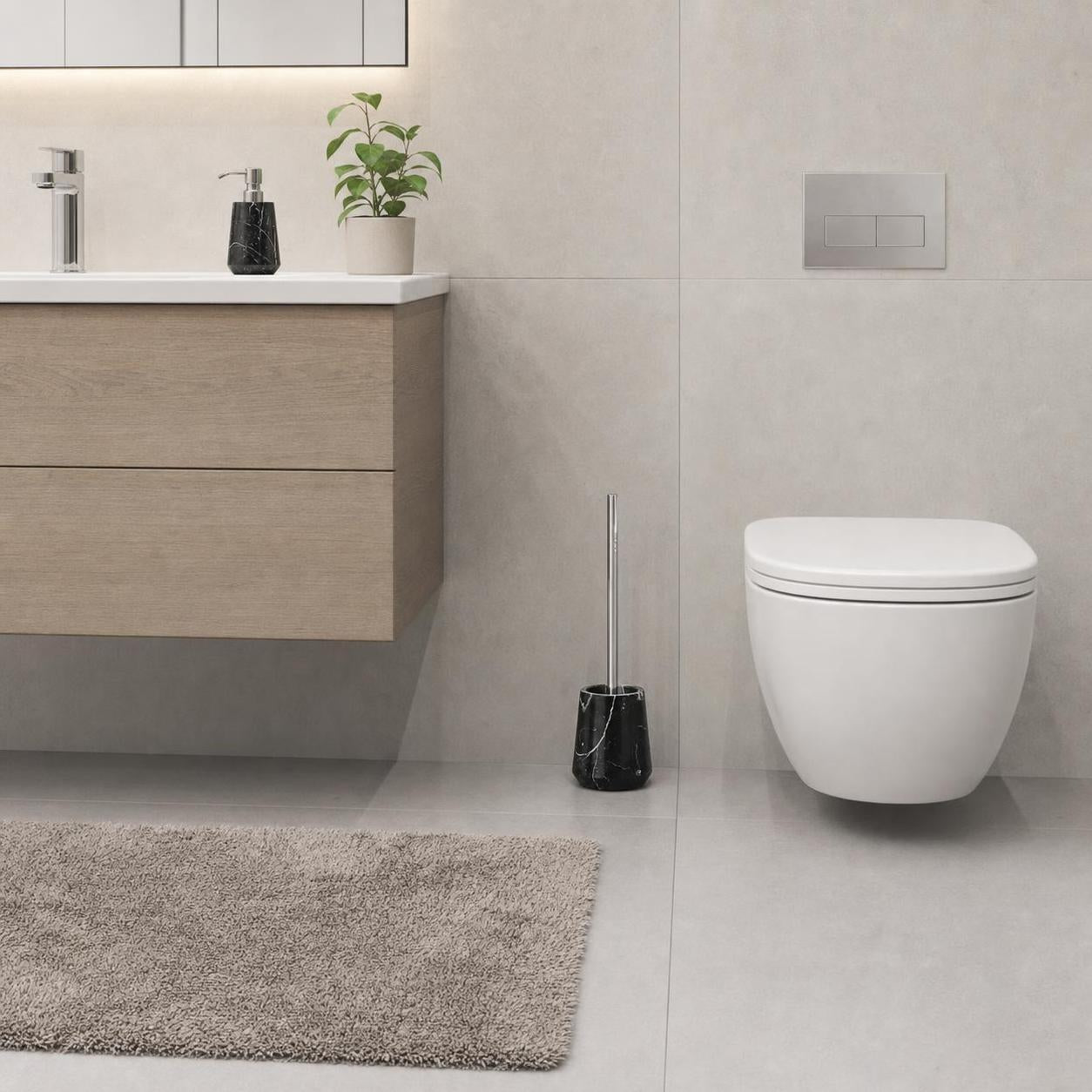 Schwarze WC-Bürste in Marmoroptik steht neben einem weißen Hänge-WC.