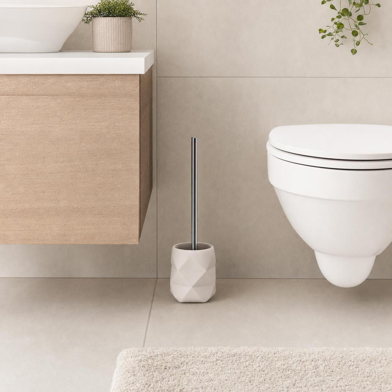 Weiße WC-Bürste im facettierten Halter neben der Toilette.