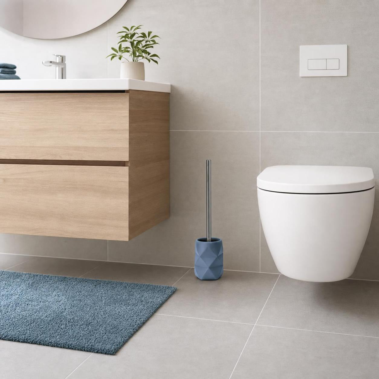 Blaue WC-Bürste im Halter steht neben Toilette im modernen Bad.
