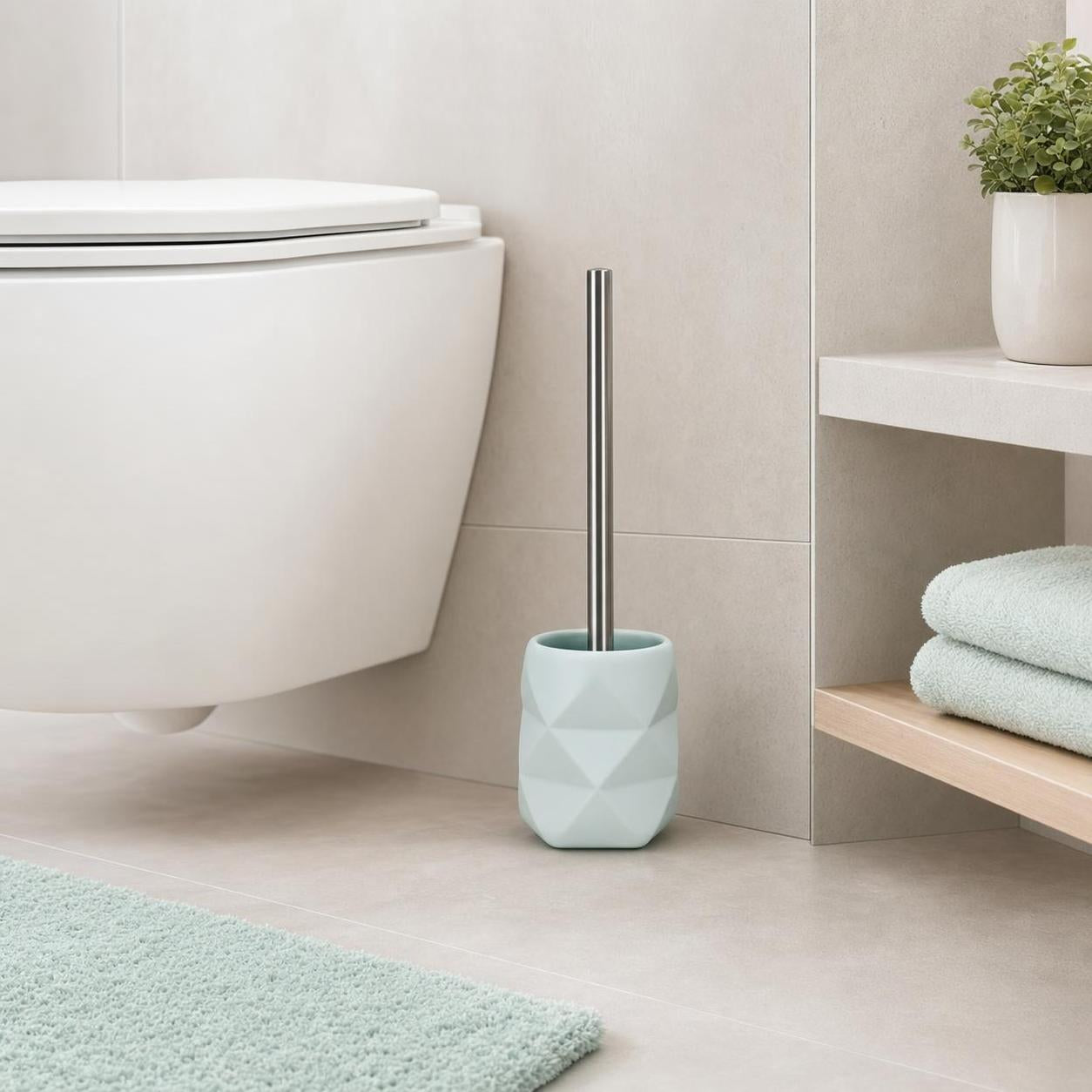Hellblauer WC-Bürstenhalter steht neben der Toilette im Bad.