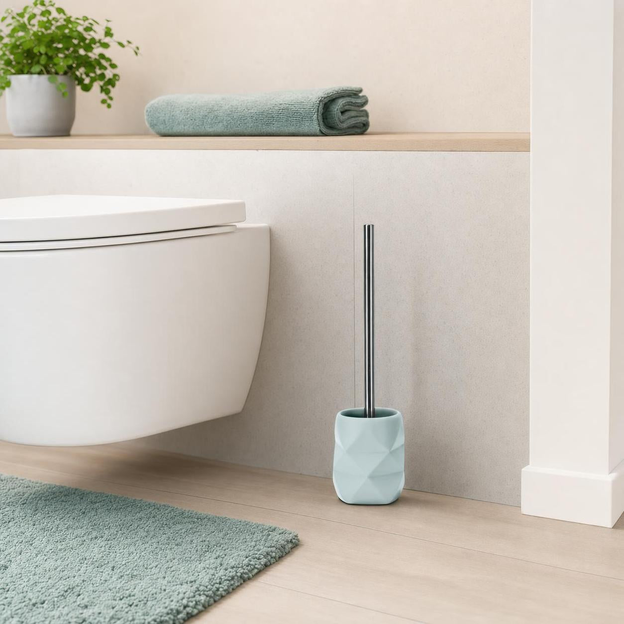 Hellblaue WC-Bürste mit Halter steht neben der Toilette im Bad.