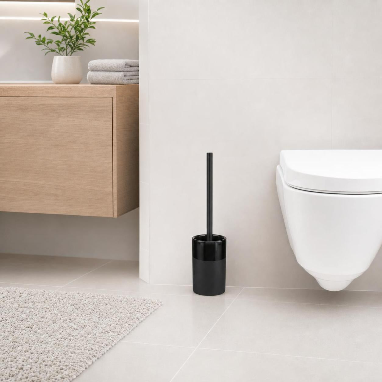 Eine schwarze WC-Bürste steht neben der Toilette im modernen Bad.