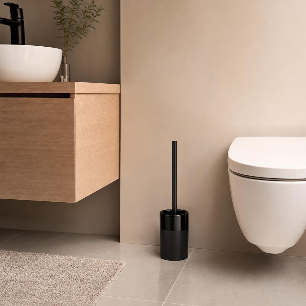 Schwarze WC-Bürste steht neben wandhängender Toilette im modernen Bad.