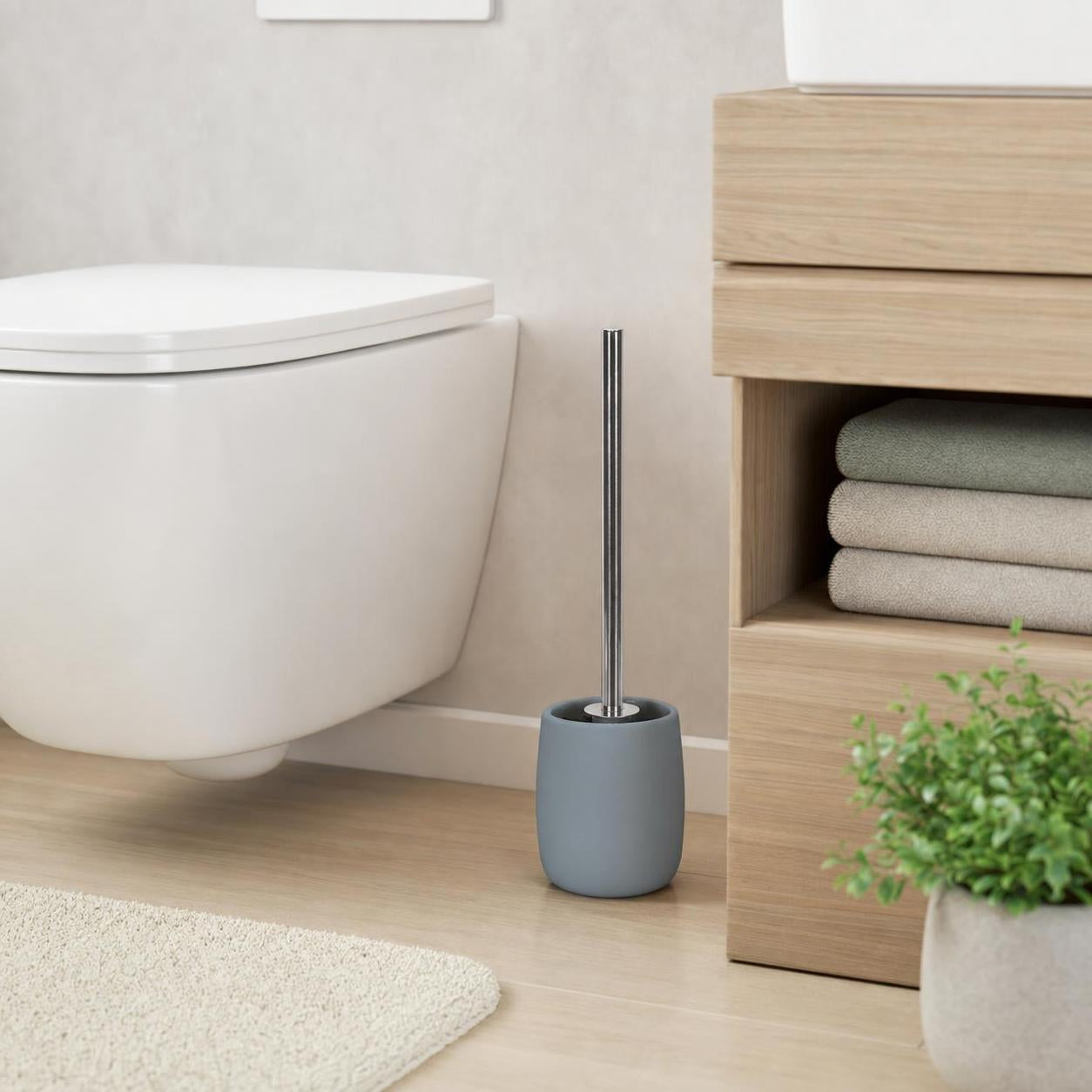 Graue WC-Bürste mit Halter steht neben der Toilette im modernen Bad.