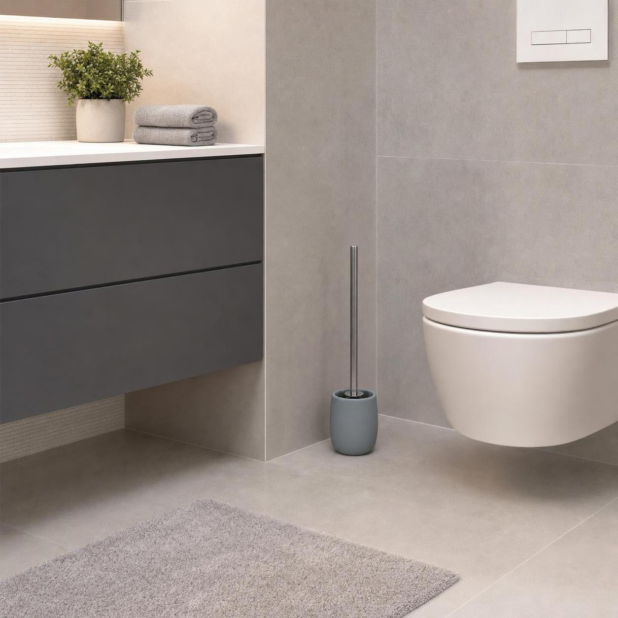 Graue WC-Bürstengarnitur steht neben der Toilette im modernen Bad.