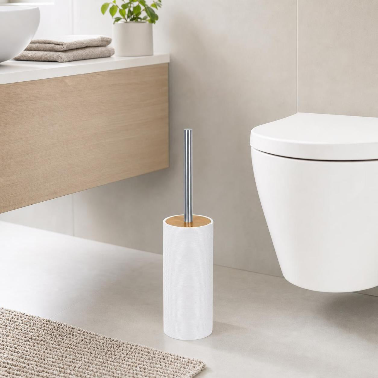 Weiße WC-Bürste im zylindrischen Halter steht neben der Toilette.
