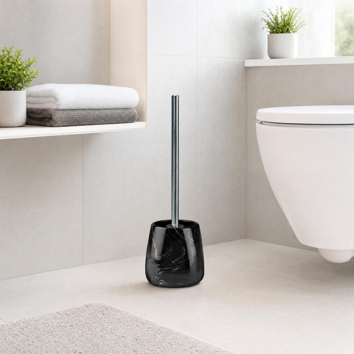 Schwarze WC-Bürste in modernem Bad neben Wand-WC und gefalteten Handtüchern.