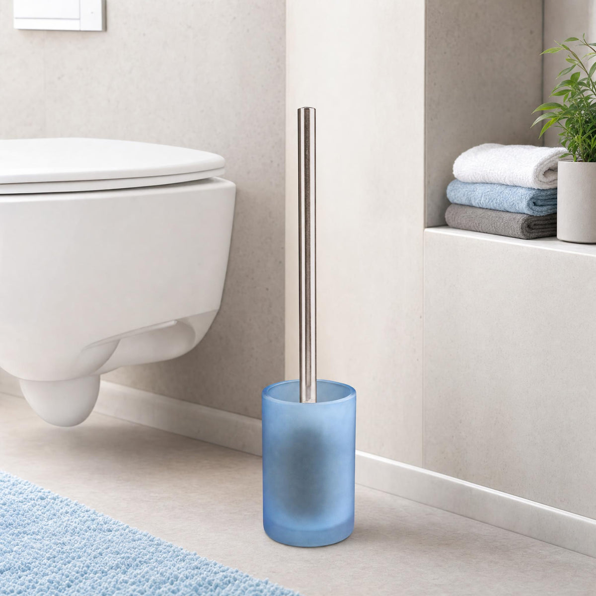 Blaue WC-Bürste aus Glas neben Hänge-WC in modernem Badezimmer.