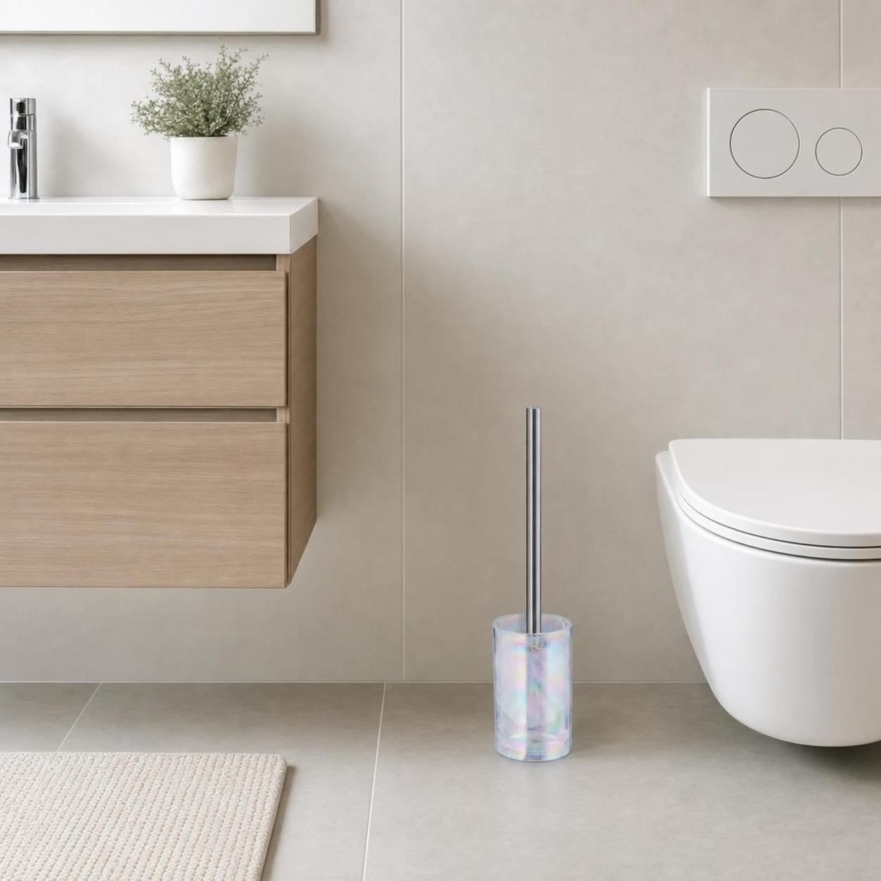 Eine WC-Bürste mit schimmerndem Halter steht neben der Toilette.