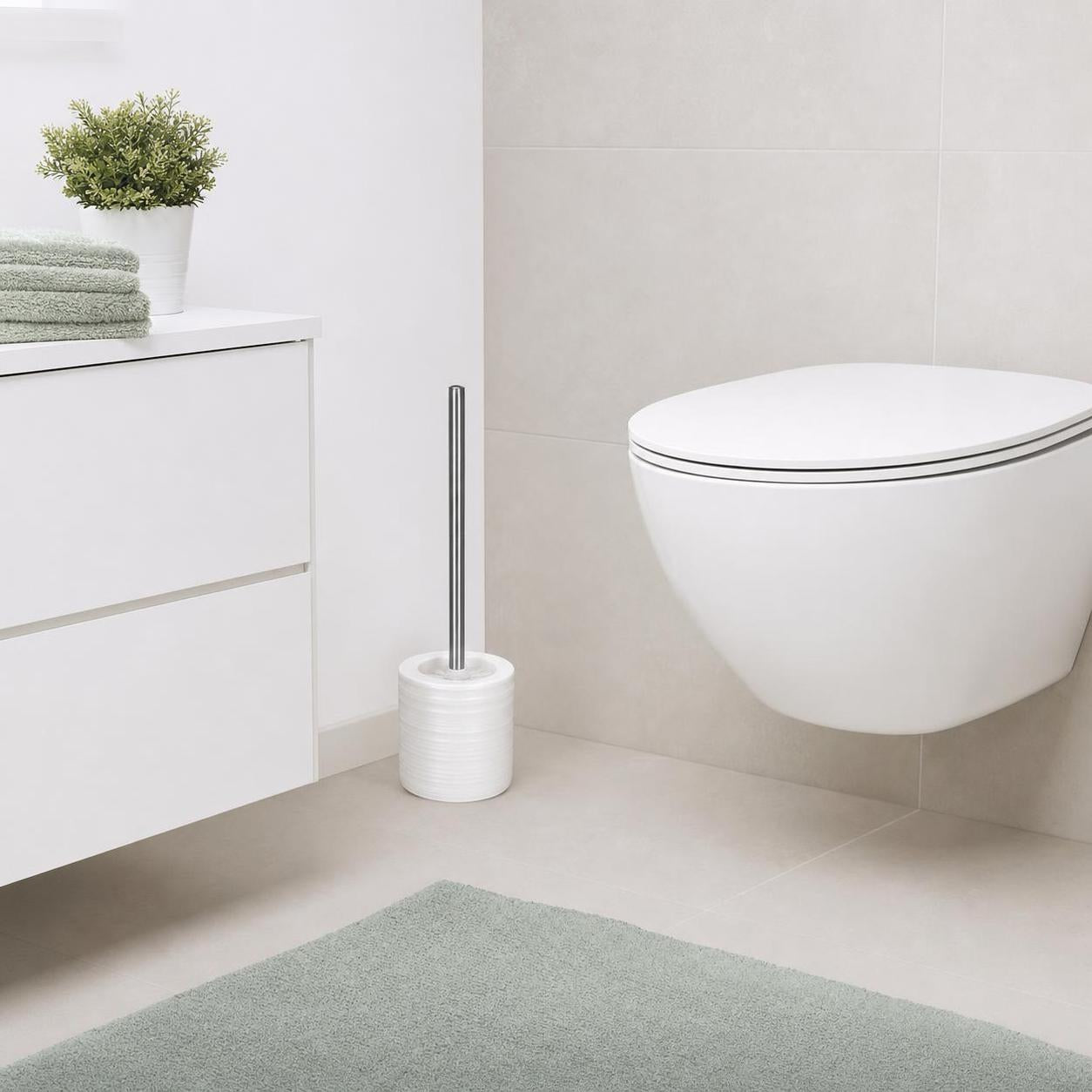Weiße WC-Garnitur mit Metallgriff steht neben der Toilette im Bad.