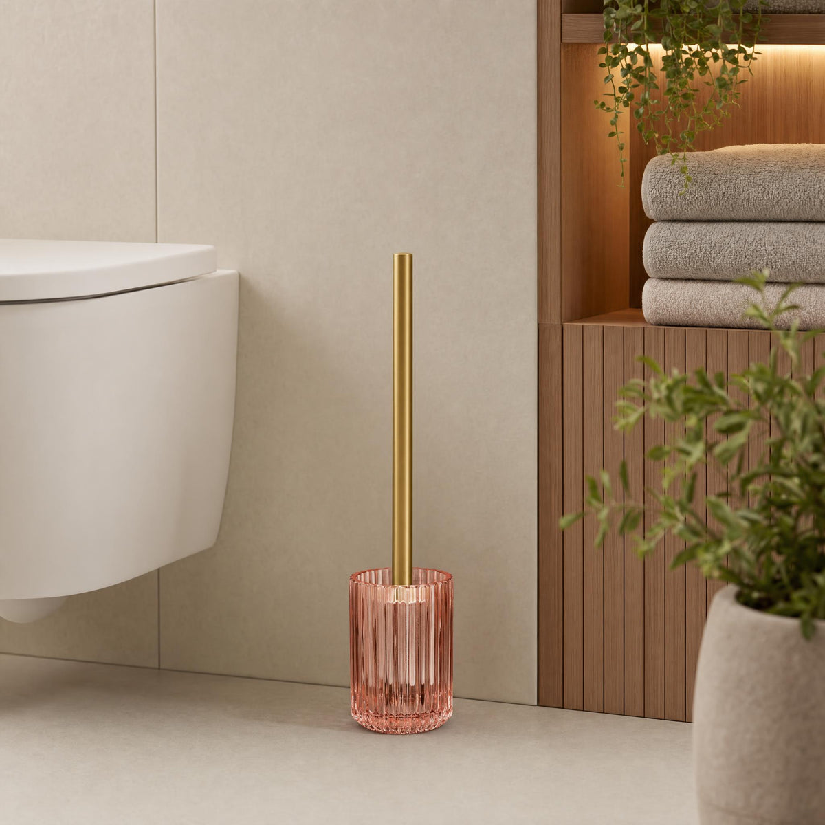 Rosa WC-Garnitur mit goldfarbenem Handgriff in modernem Bad.
