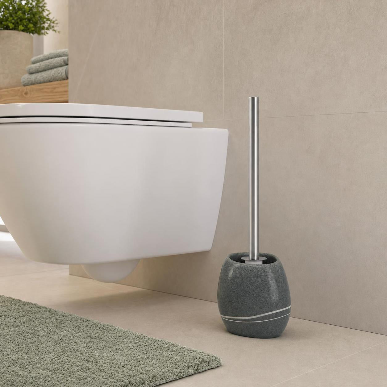 Graue WC-Bürste mit Halter steht neben einer weißen Toilette.