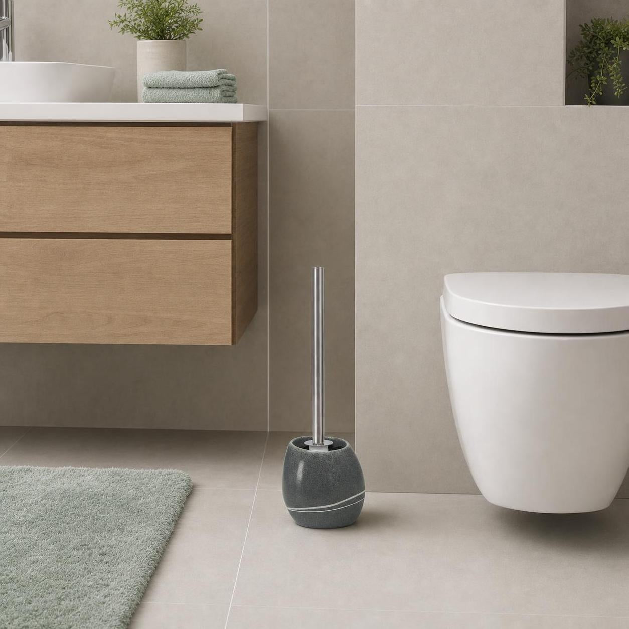 Graue WC-Bürste mit Halter steht neben der Toilette im modernen Bad.