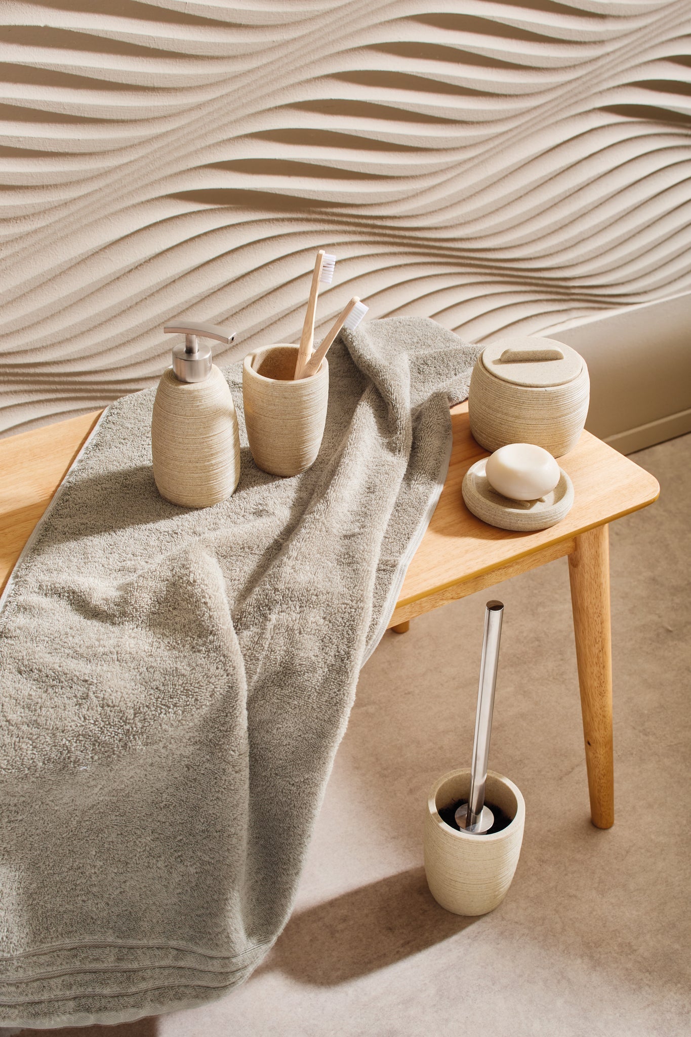 WC-Bürsten-Halter SAND Macadamia auf Holzbank mit Handtuch und passendem Bad-Set im Badezimmer.