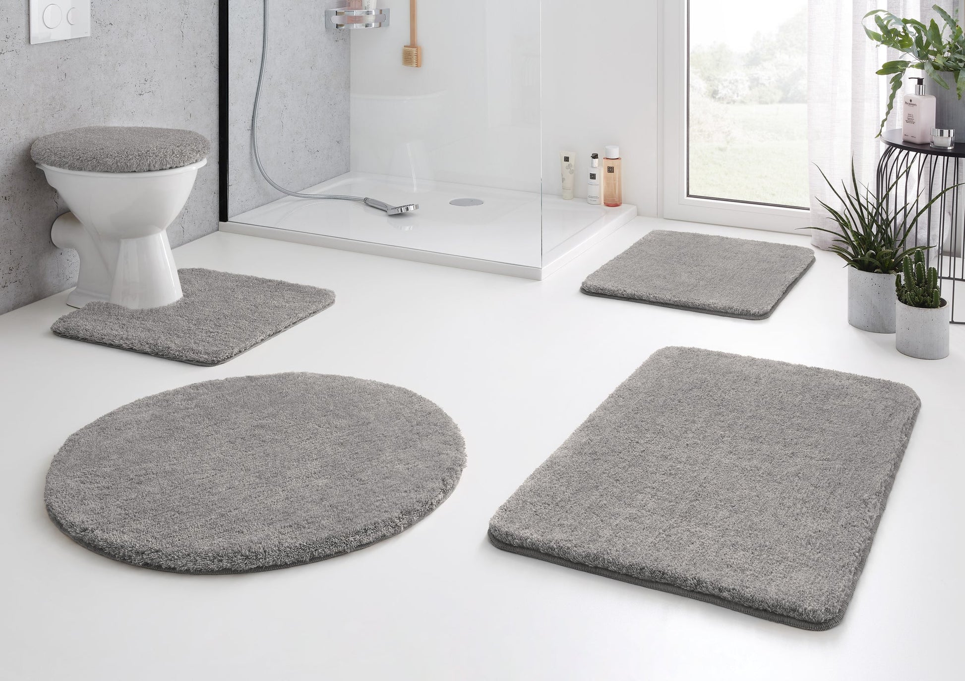 Modernes Bad mit grauen Badematten-Set und WC-Deckelbezug aus Textil