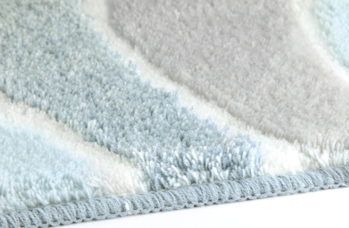 Detailansicht eines flauschigen Badteppichs mit hellblauen Streifen.
