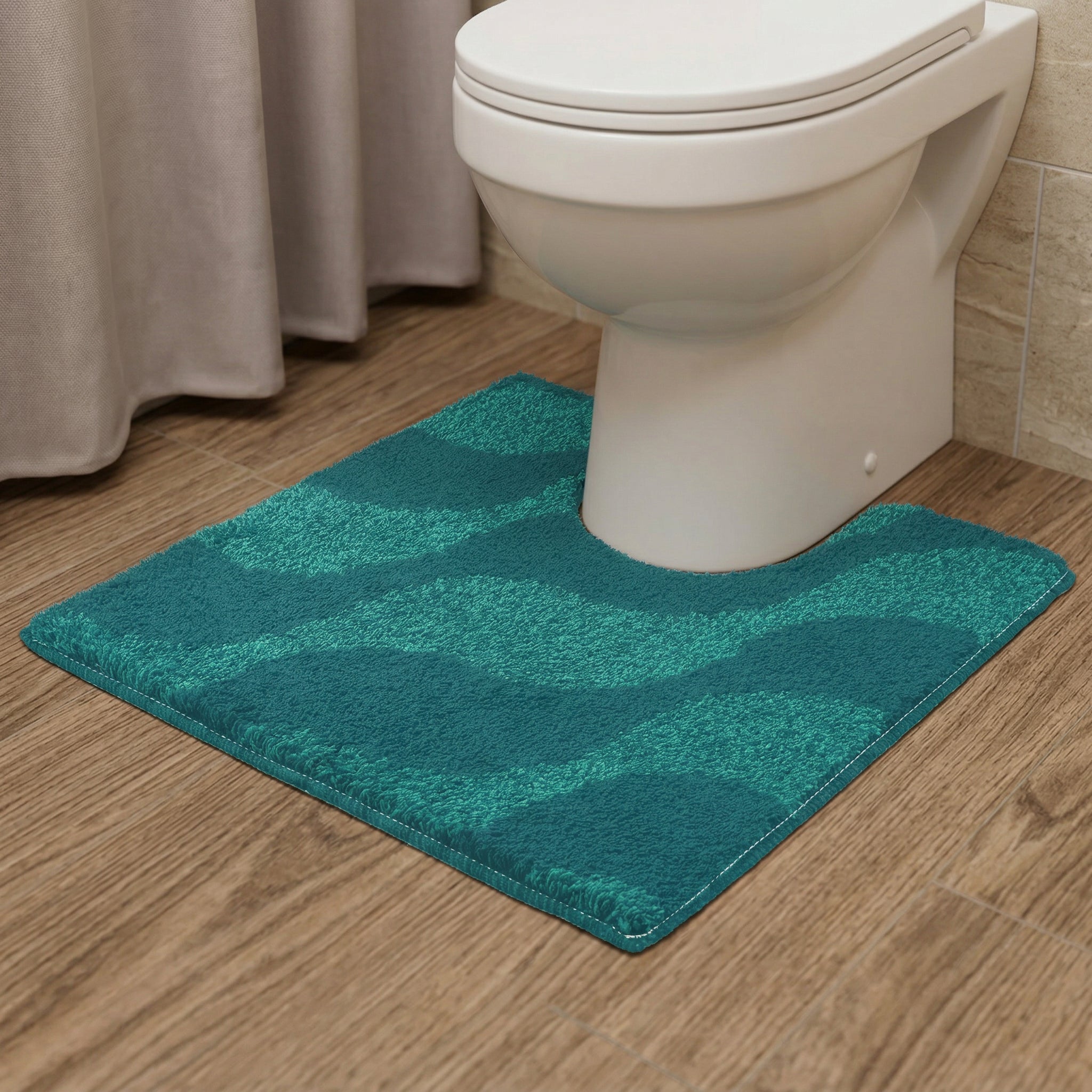 Türkisgrüne WC-Vorlage mit Wellenmuster auf braunem Holzfußboden im Bad